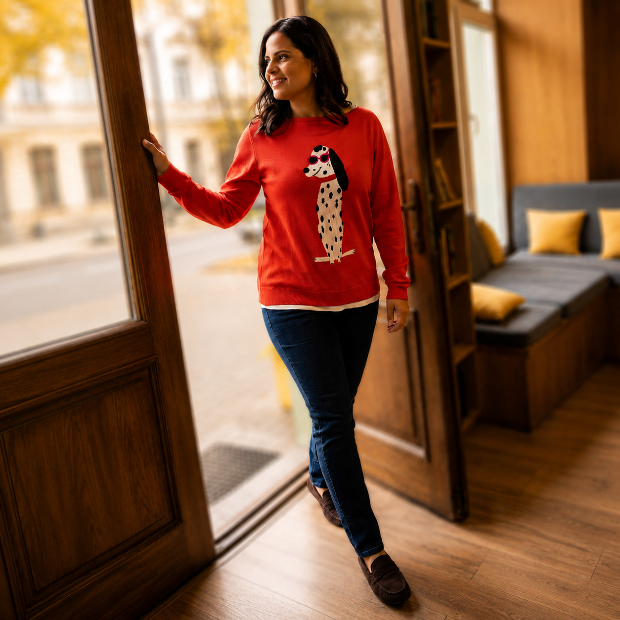 chica morena con Jersey rojo con estampado de la marca october.es - Mujer entrando en una cafeteria de Madrid vestida con un jersey rojo, pantalones vaqueros y mocasines